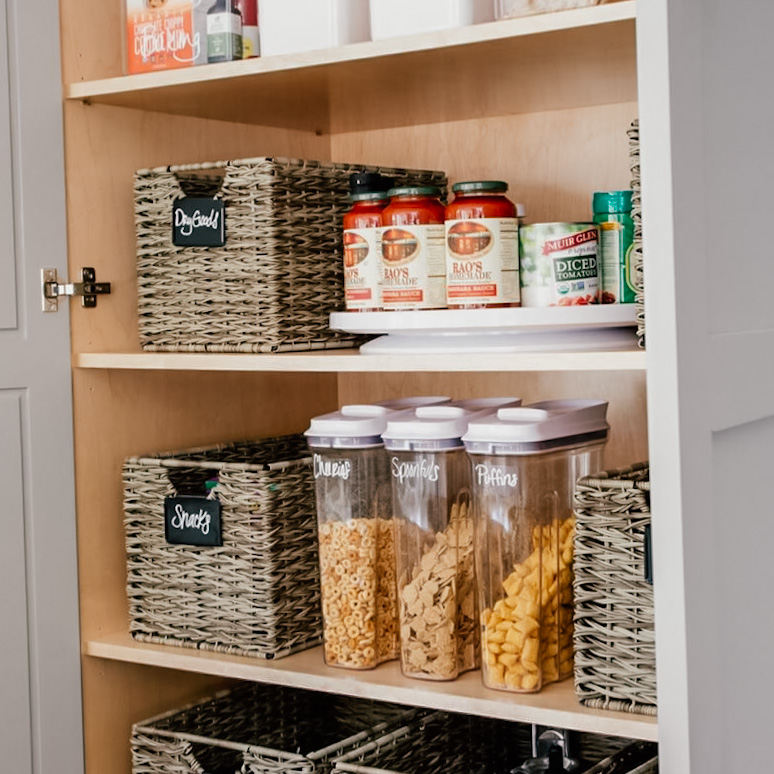 Image Description: Three cereal canisters sit between labeled bins in a pantry