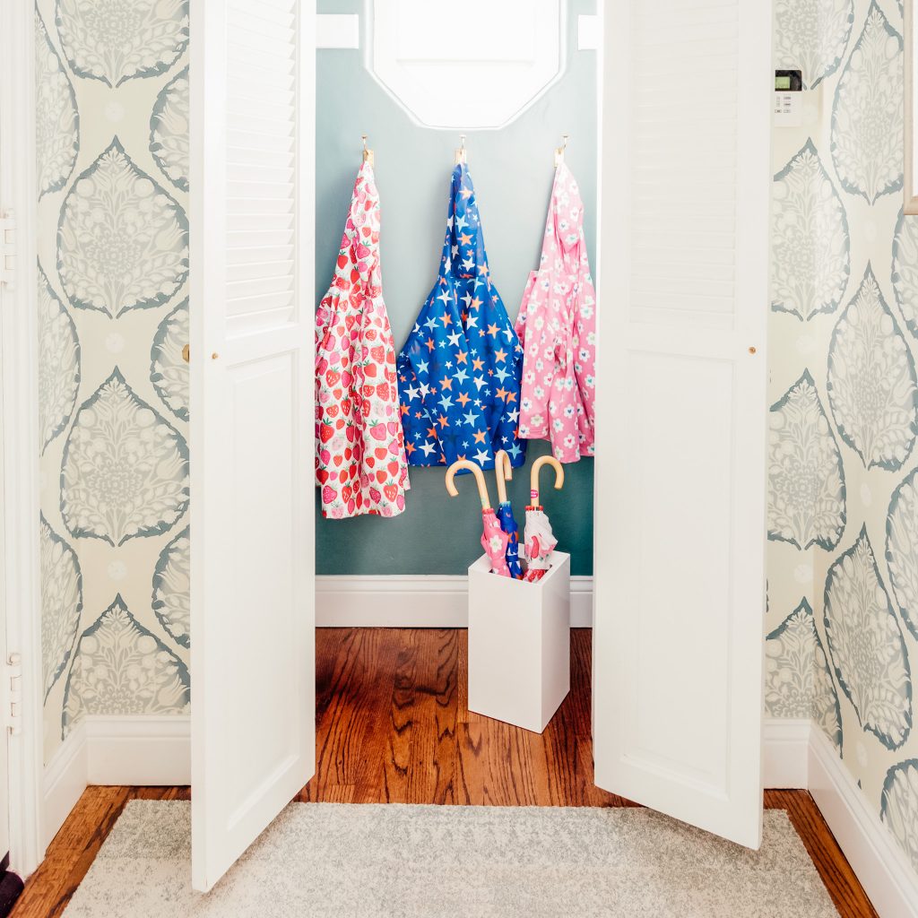Image Description: An entry closet with three polka dot raincoats and a bin of umbrellas