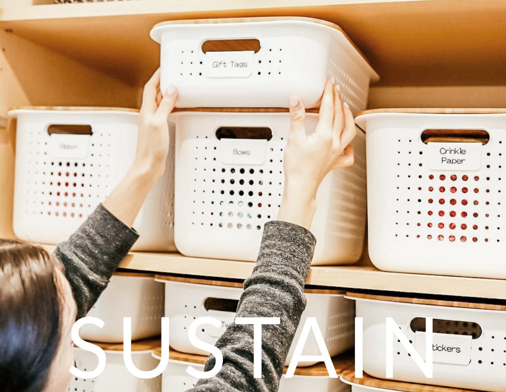 Image Description: An organizer places a white labeled bin onto a shelf