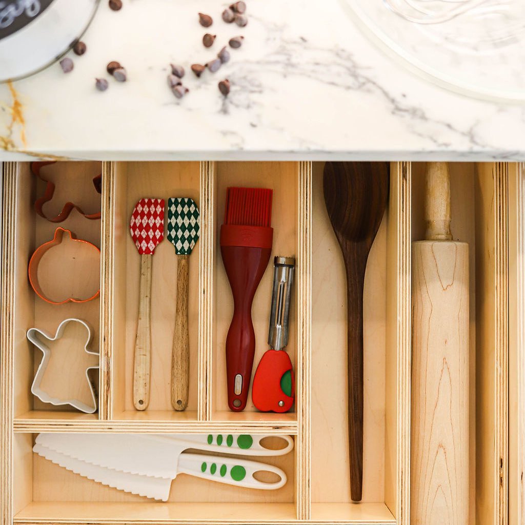 Image Description: A pull out drawer with custom dividers that separate cookie cutters, spatulas and other baking items. 