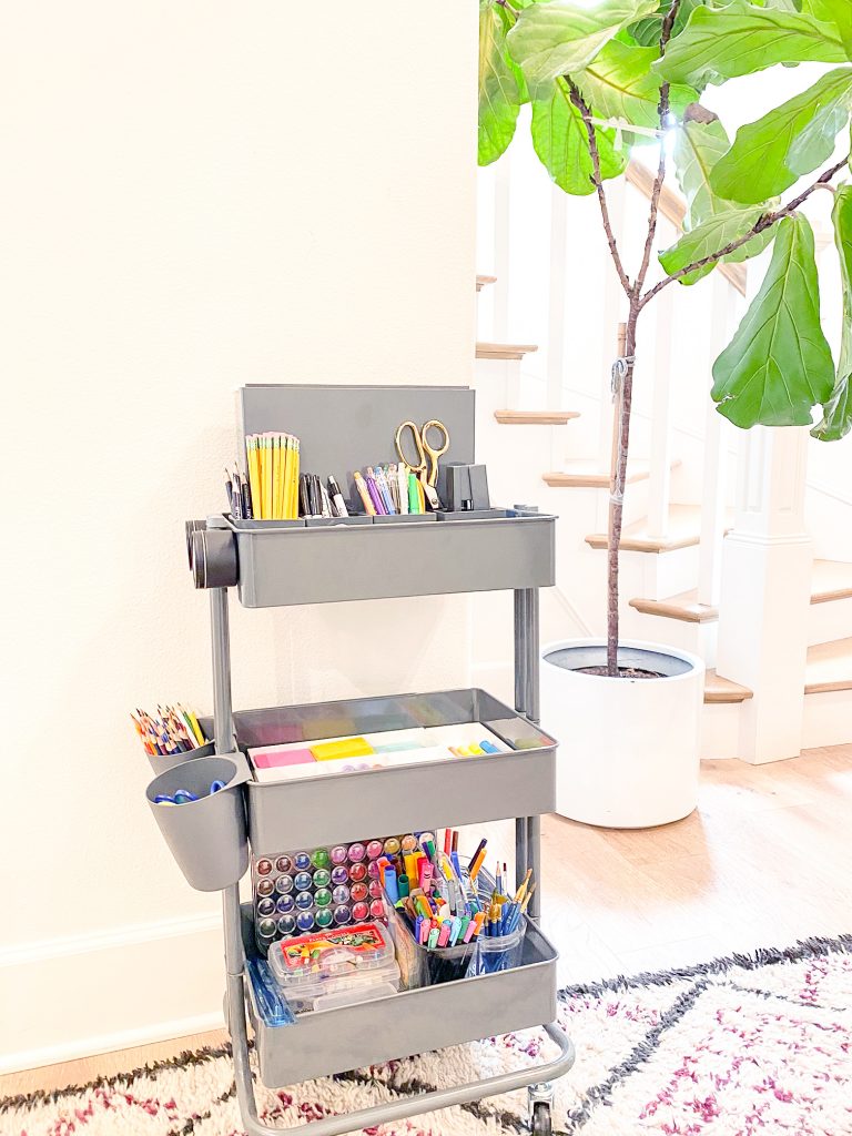 Image Description: A gray rolling cart filled with various school supplies sits against a wall