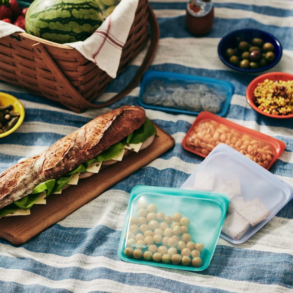 Image Description: A picnic spread is laid out on a striped blanket