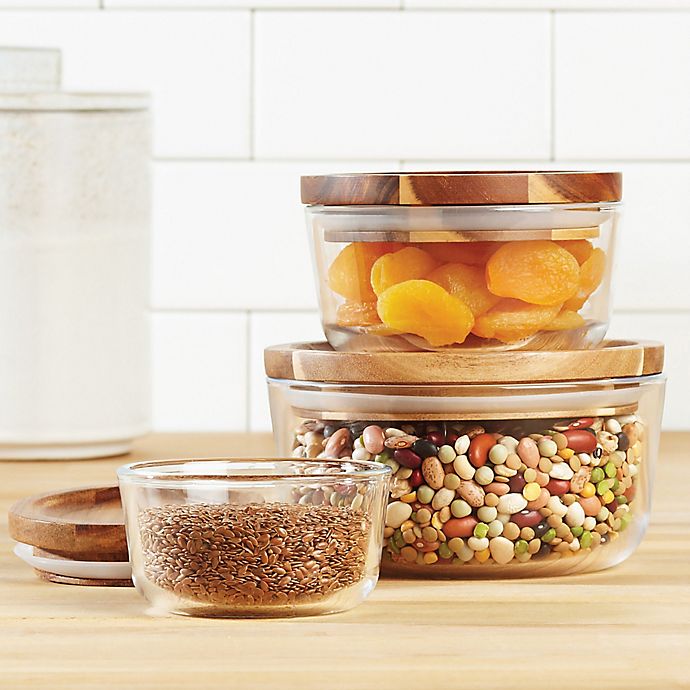 Image Description: A set of glass containers with wooden lids, on a wooden countertop.