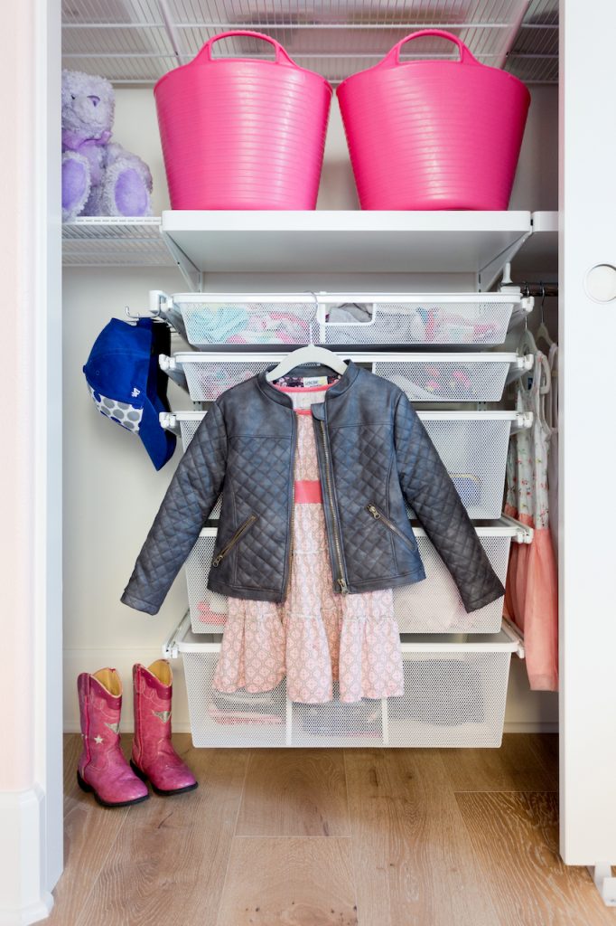 Image Description: A dress and jacket are hung at the front of a closet, next to pink cowboy boots